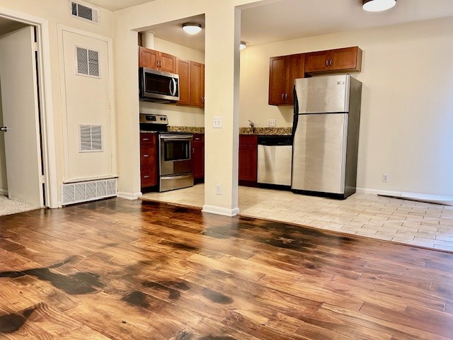 2800 Cole Street, Unit 102C Austin, TX 78705 - Photo 2 of 8 a view of a refrigerator in kitchen and an empty room with wooden floor