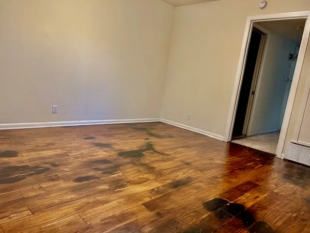 an empty room with wooden floor and door