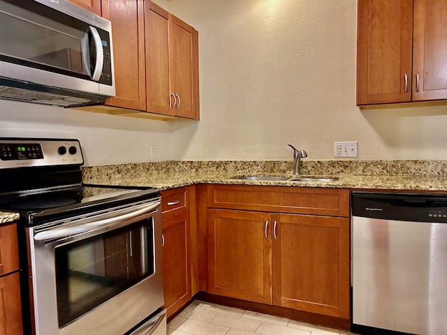 2800 Cole Street, Unit 102C Austin, TX 78705 - Photo 4 of 8 a kitchen with granite countertop stainless steel appliances and wooden cabinets