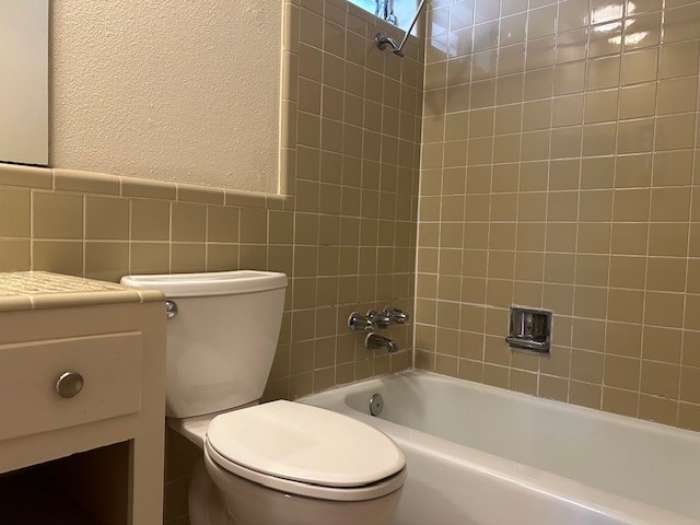 2800 Cole Street, Unit 102C Austin, TX 78705 - Photo 5 of 8 a white toilet sitting next to a bath tub