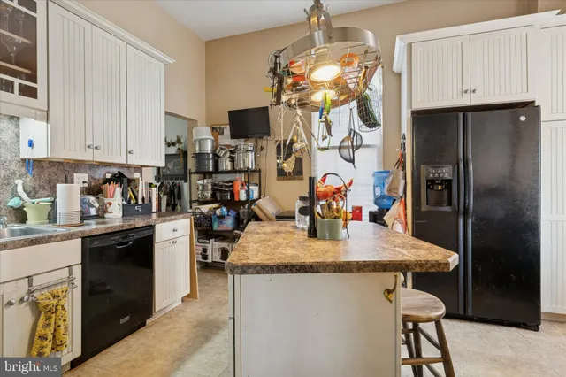 a kitchen with stainless steel appliances granite countertop a sink a refrigerator and a stove top oven
