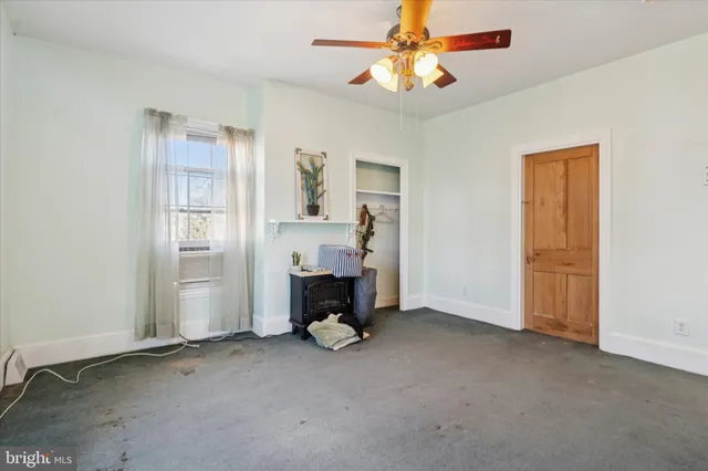 a view of empty room with fireplace and fan