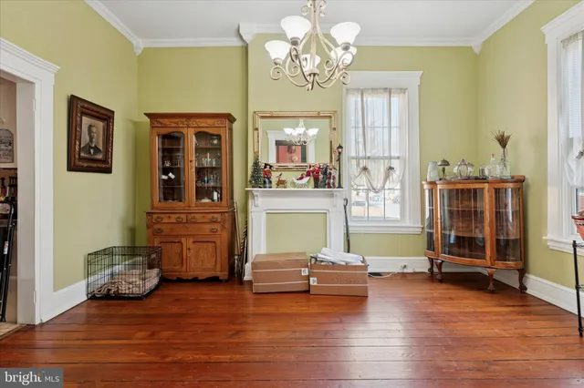 a view of a livingroom with furniture a chandelier and wooden floor