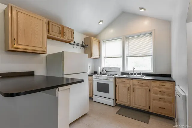 a kitchen with granite countertop white cabinets and white appliances