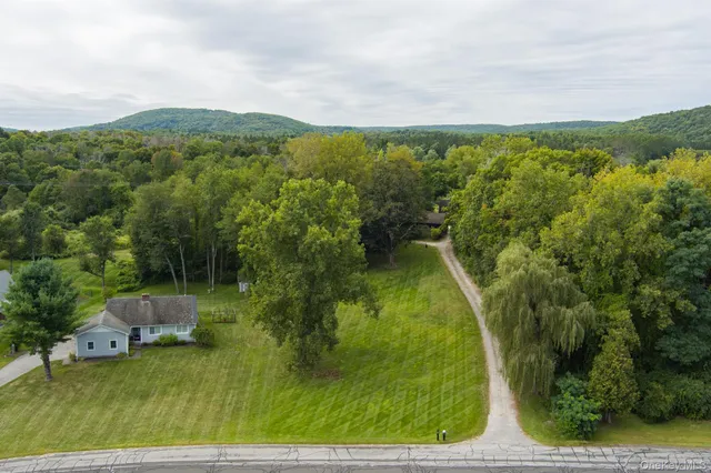 a view of residential houses with outdoor space and trees