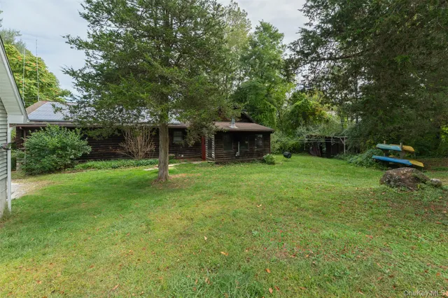 a view of a house with backyard and a tree