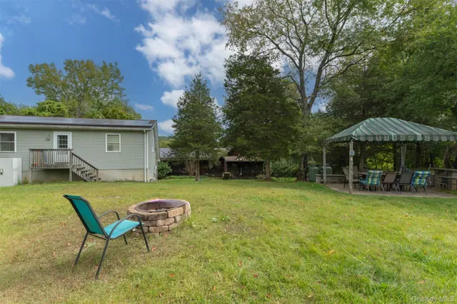 a view of a house with backyard and sitting area