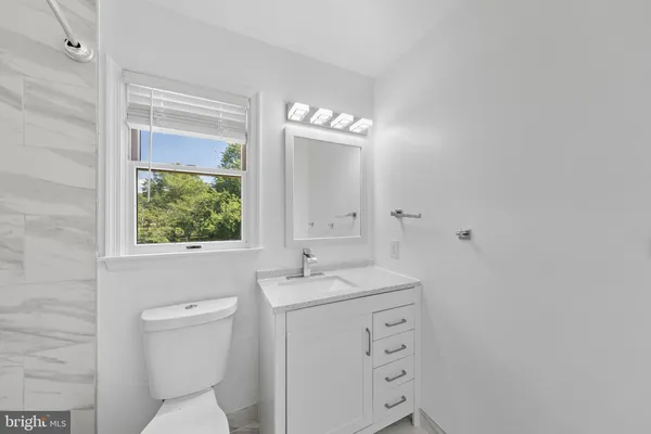 a bathroom with a toilet a sink a vanity and mirror