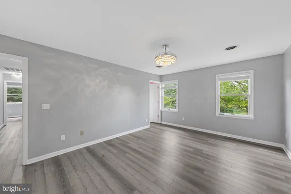 an empty room with wooden floor and window