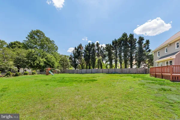 a view of a grassy field with trees in the background
