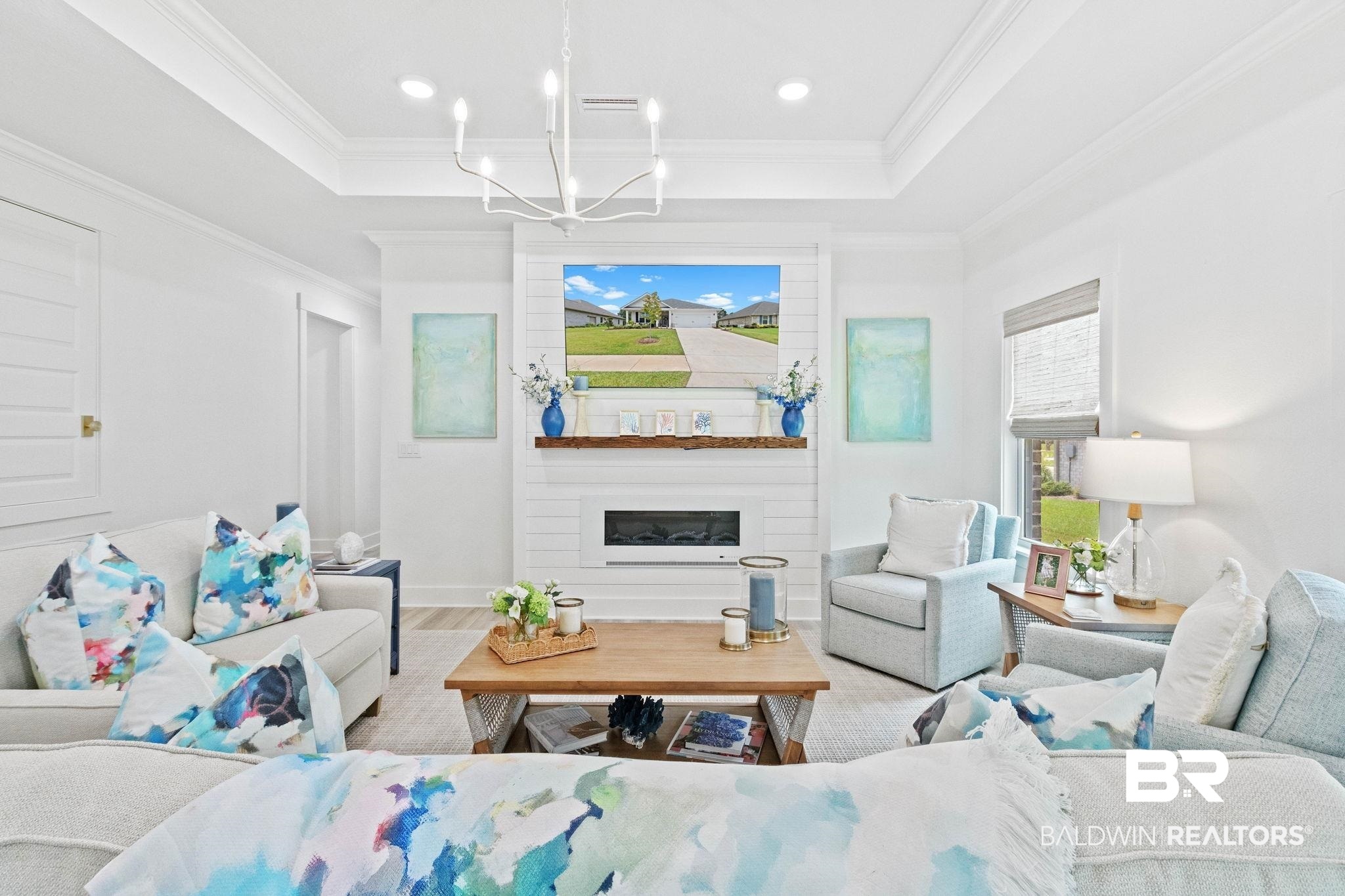 9815 Lakeview Drive Foley, AL 36535 - Photo 18 of 100 Living room featuring a fireplace, a tray ceiling, crown molding, and a chandelier
