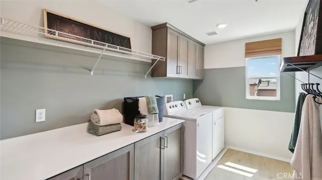 a utility room with cabinets washer and dryer