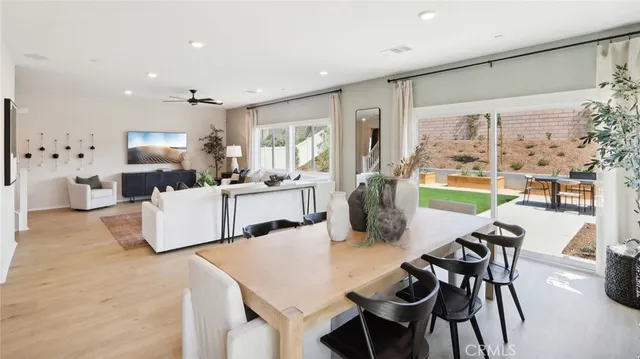 a living room with furniture a large window and a dining table