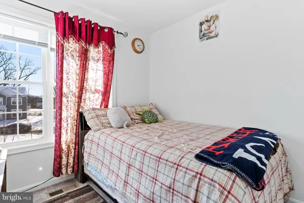 a bedroom with a bed and a painting on the wall