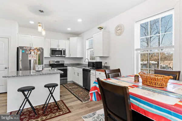 a living room with stainless steel appliances furniture and a kitchen view