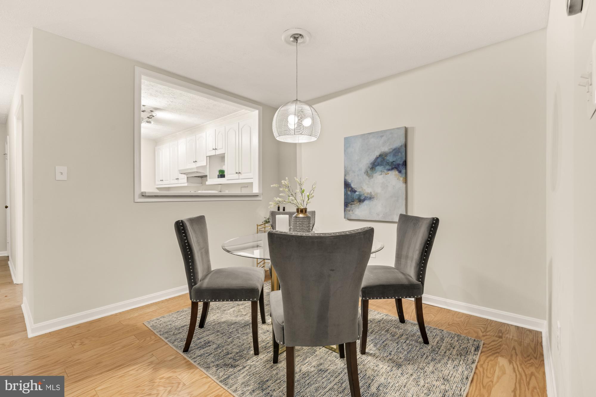 45 Windbrooke Circle, Unit 45 Gaithersburg, MD 20879 - Photo 15 of 29 a dining room with furniture wooden floor a rug and a chandelier