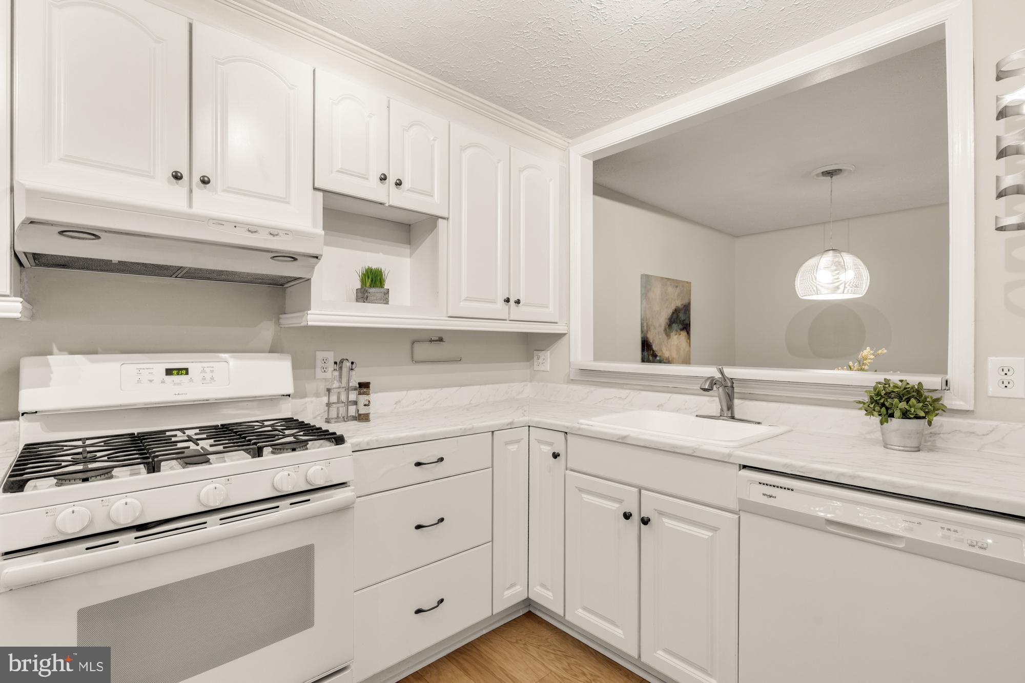 45 Windbrooke Circle, Unit 45 Gaithersburg, MD 20879 - Photo 7 of 29 a kitchen with white cabinets and appliances