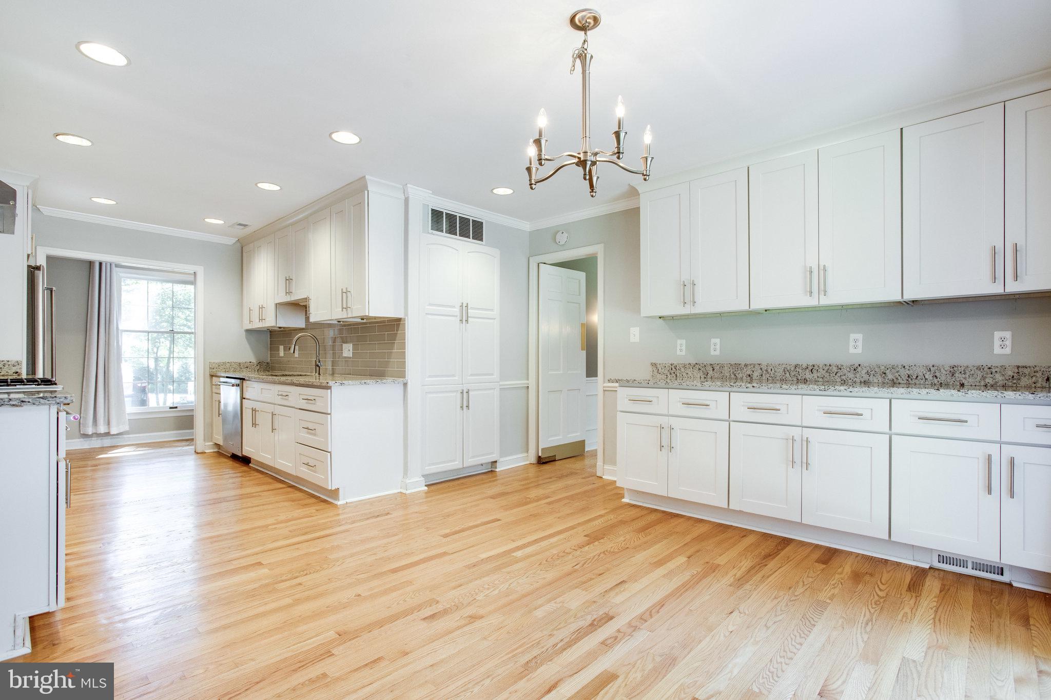 8500 Brook Road McLean, VA 22102 - Photo 13 of 59 a kitchen with stainless steel appliances granite countertop a stove a sink and white cabinets with wooden floor