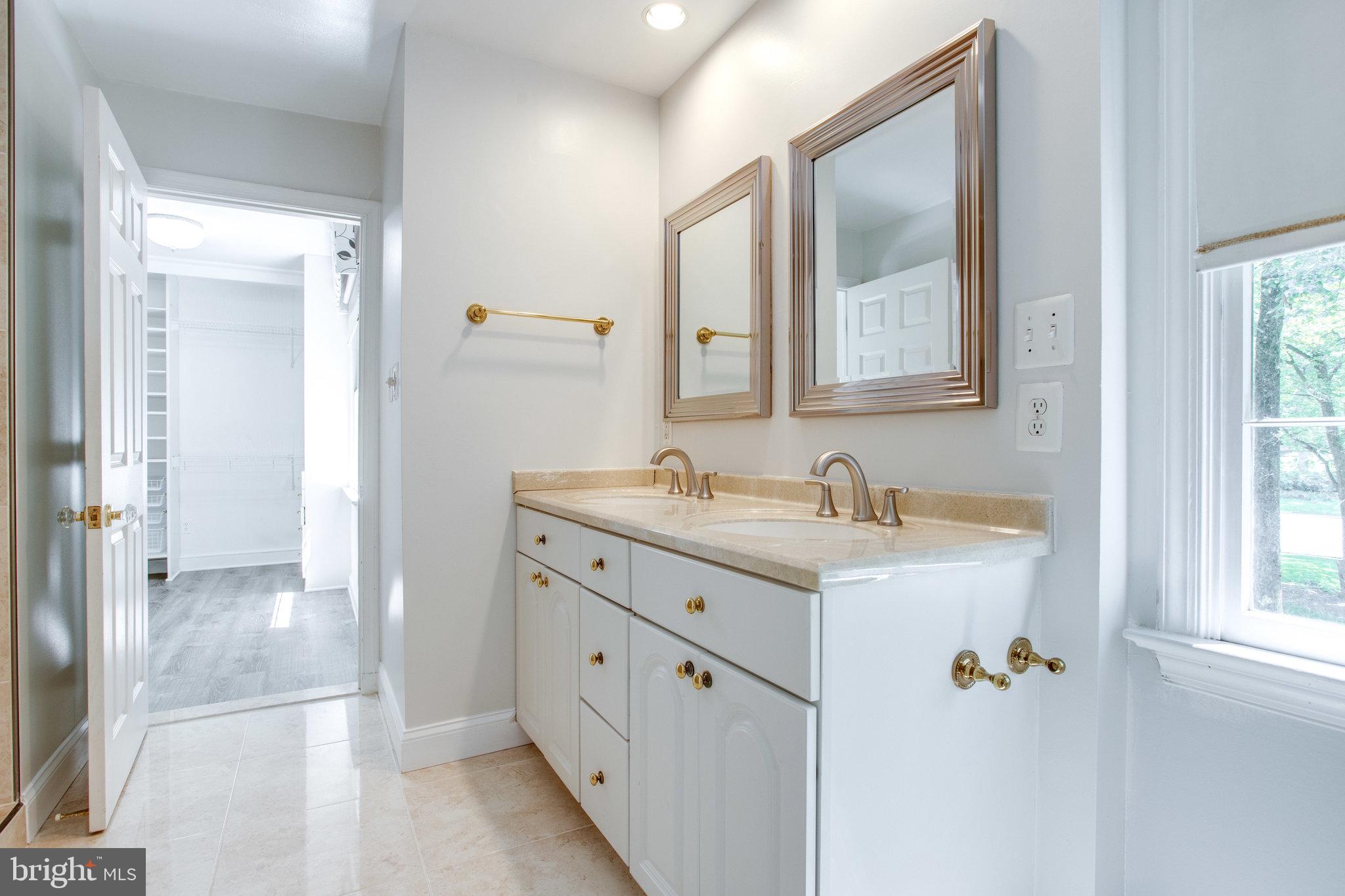 8500 Brook Road McLean, VA 22102 - Photo 37 of 59 a bathroom with a granite countertop sink a mirror and a shower