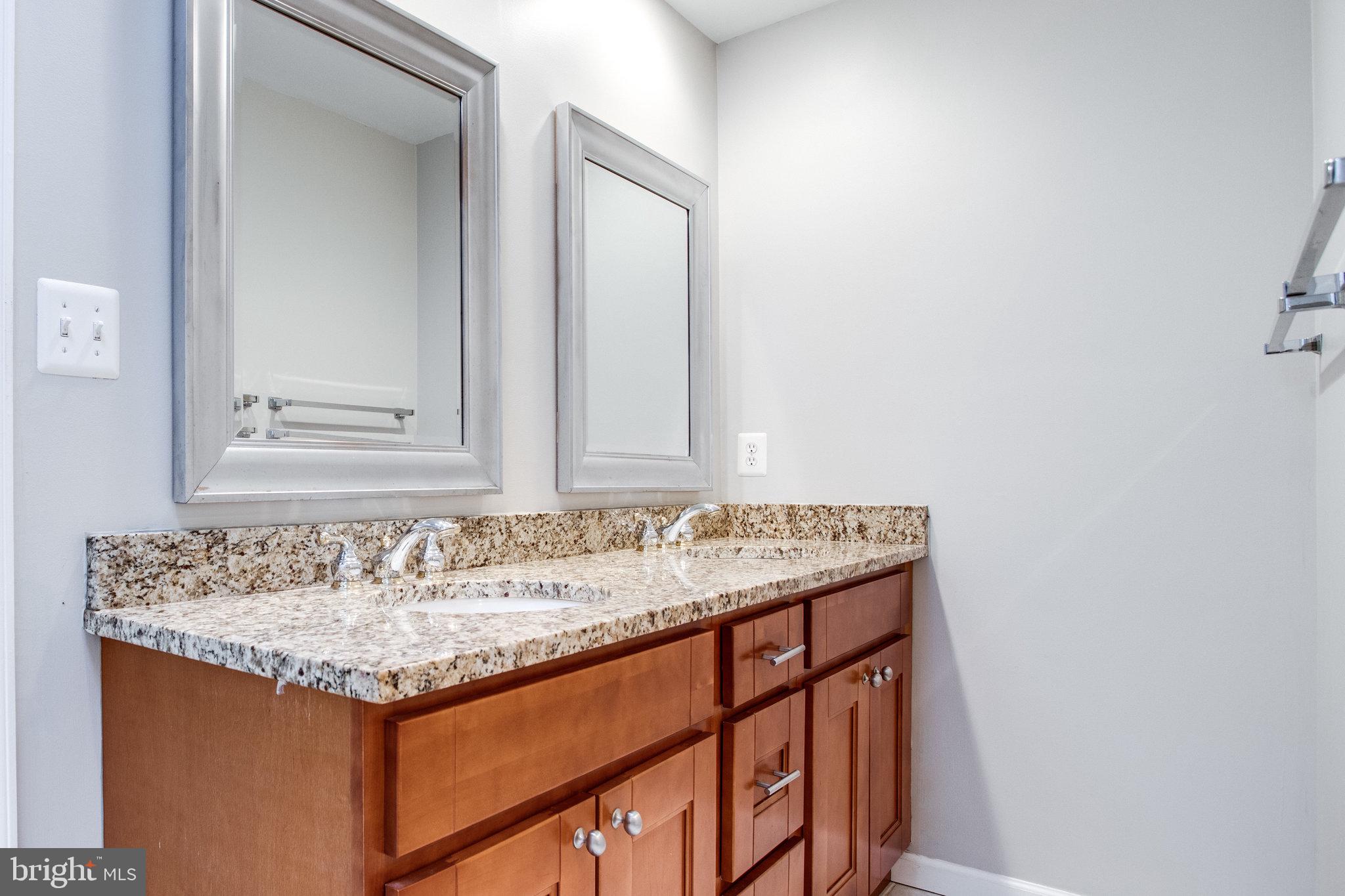 8500 Brook Road McLean, VA 22102 - Photo 44 of 59 a bathroom with a granite countertop sink and a mirror
