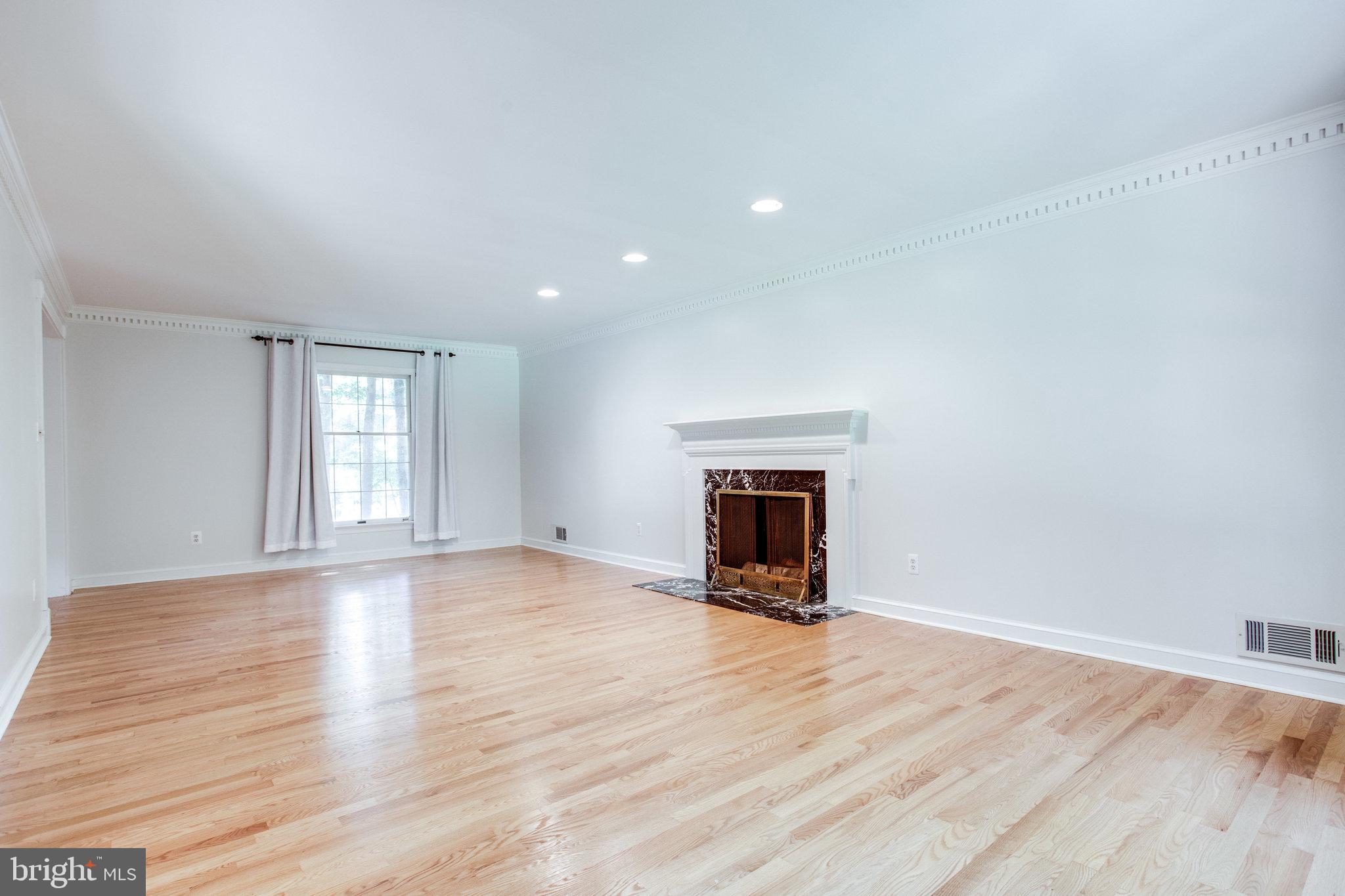8500 Brook Road McLean, VA 22102 - Photo 6 of 59 a view of empty room with wooden floor and fireplace