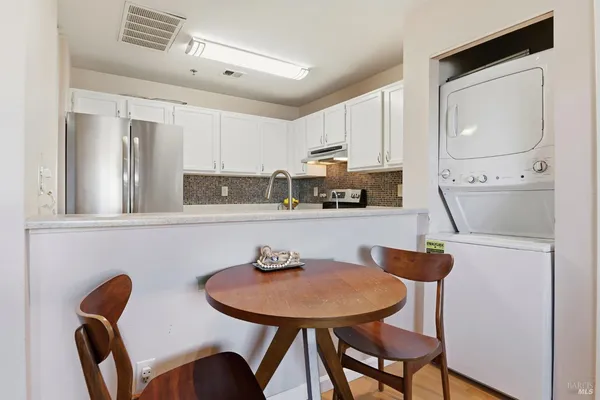 a kitchen with stainless steel appliances a dining table and chairs
