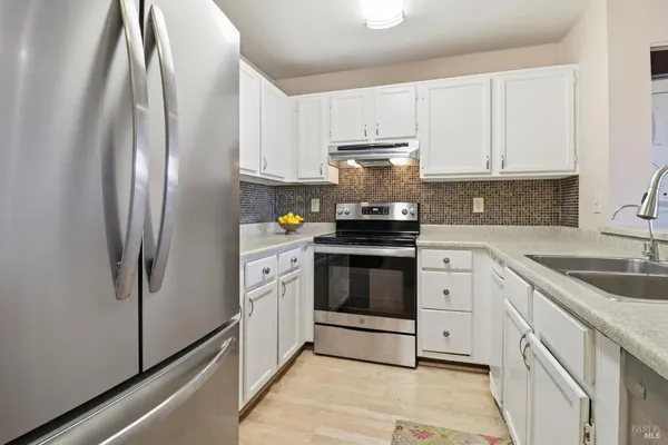 a kitchen with stainless steel appliances granite countertop a refrigerator sink and stove