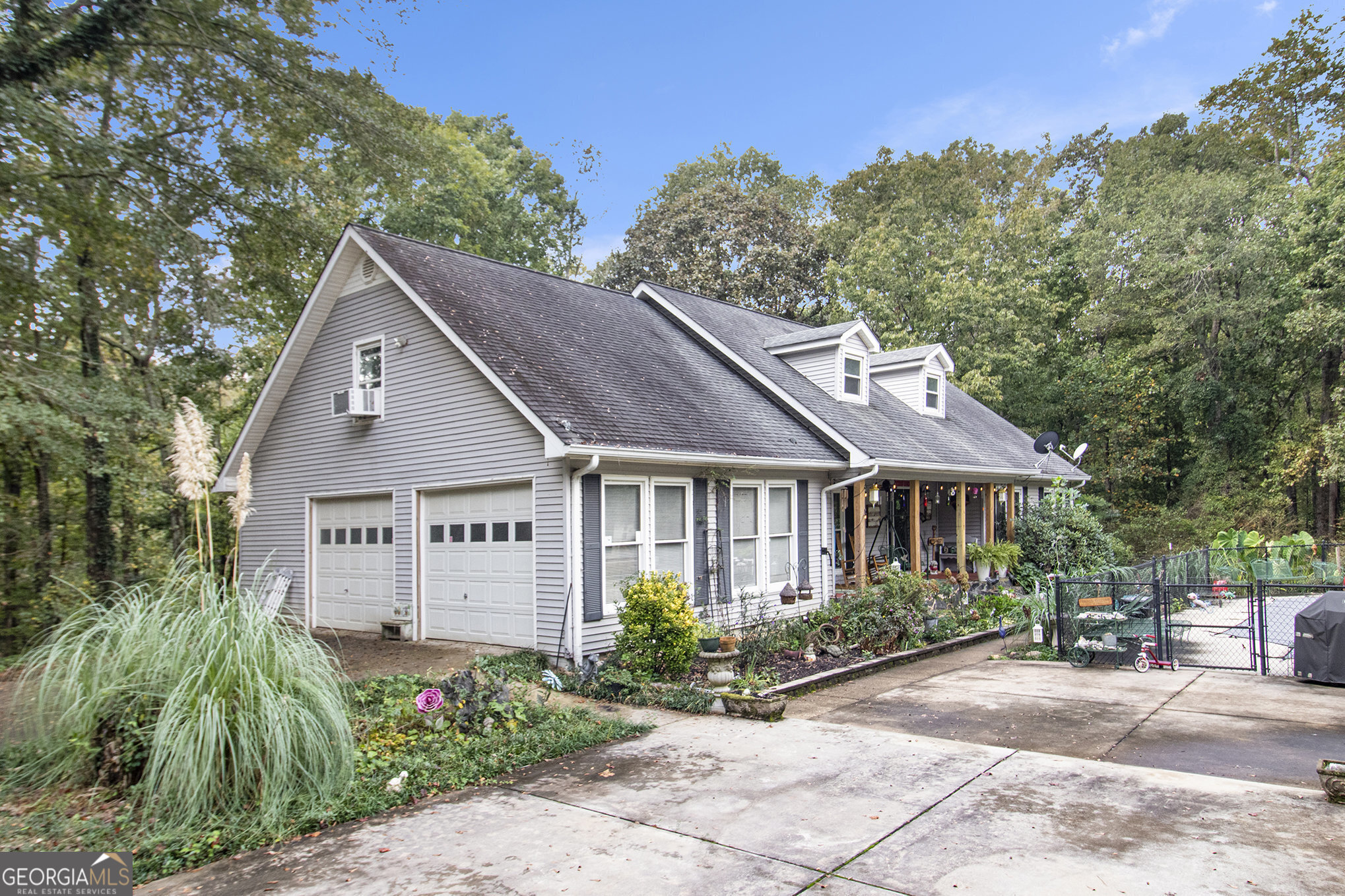 a view of a house with a small yard plants and large tree