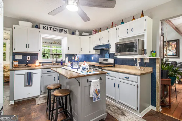 a kitchen with granite countertop a sink appliances cabinets and furniture