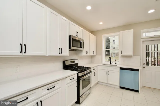 a kitchen with stainless steel appliances a sink stove and cabinets