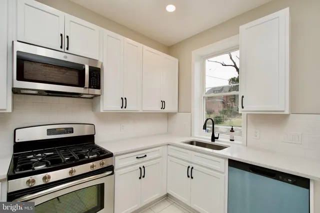 a kitchen with stainless steel appliances a sink stove and microwave