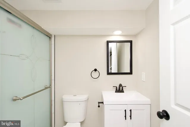 a bathroom with a sink a toilet and a mirror