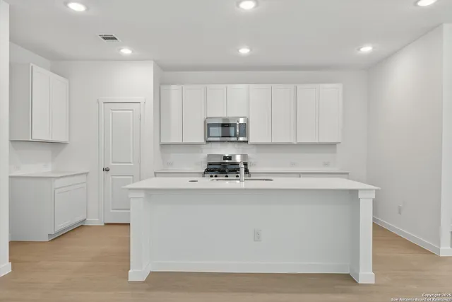 a kitchen with stainless steel appliances white cabinets and a sink