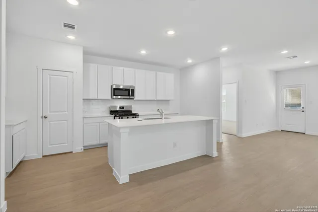 a kitchen with stainless steel appliances granite countertop a stove a sink and a refrigerator