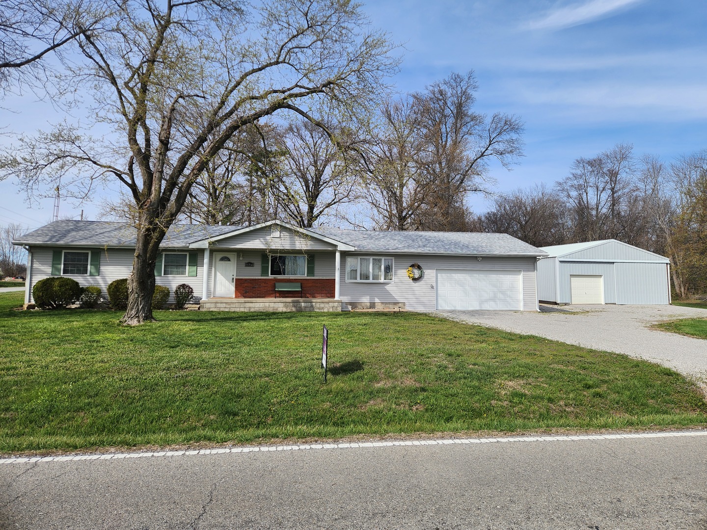 a front view of a house with a yard and trees