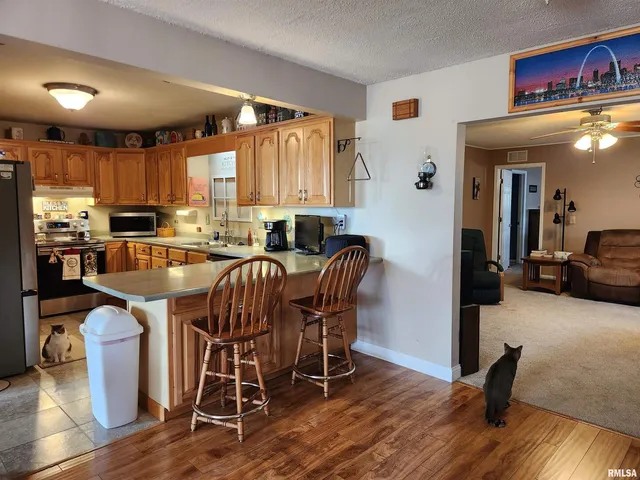 a kitchen with stainless steel appliances granite countertop a sink a stove and a refrigerator