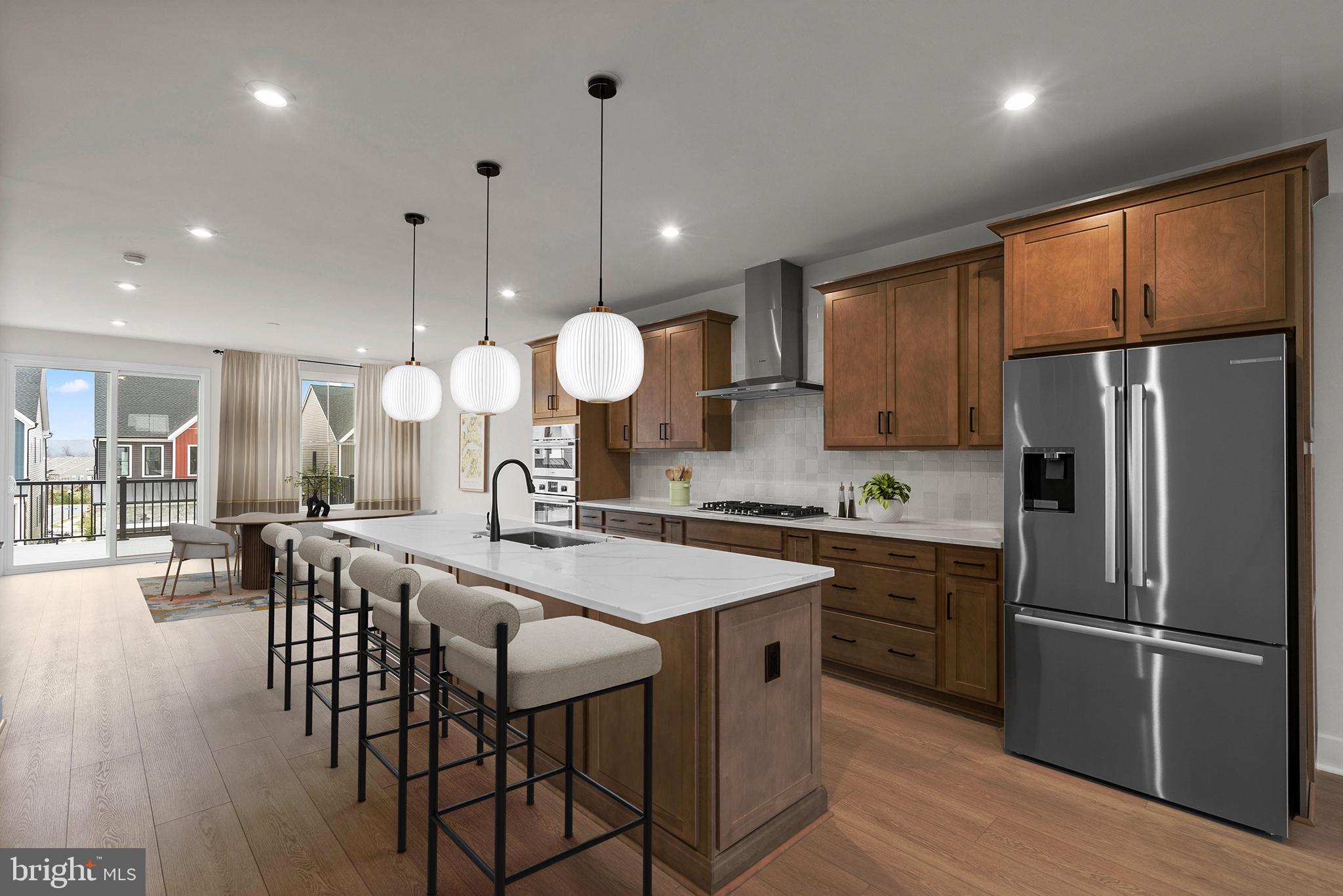 44480 Lowestoft Square Ashburn, VA 20147 - Photo 5 of 44 a kitchen with stainless steel appliances a stove a refrigerator a kitchen island a table and chairs