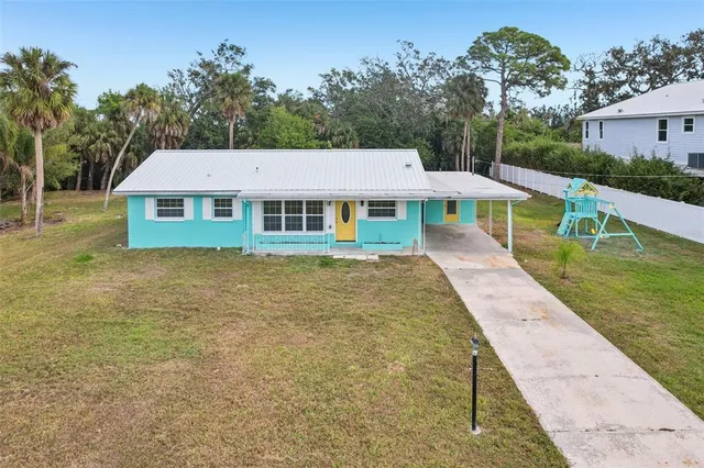a aerial view of a house with a yard table and chairs