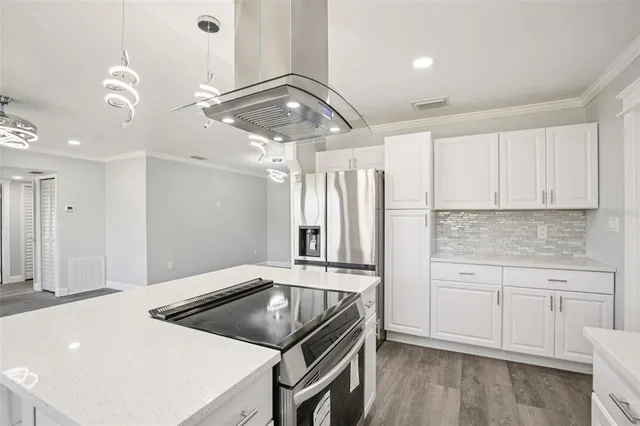 an empty room with wooden floor windows and fan