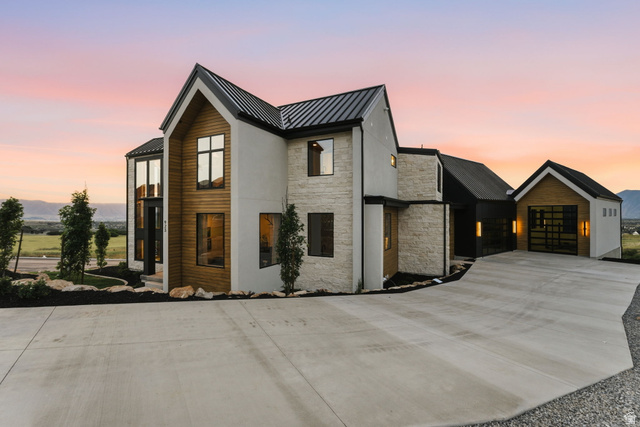 923 North Emery Lane Elk Ridge, UT 84651 - Photo 79 of 101 Modern architectural design featuring a prominent peaked roofline and a combination of white stucco, natural wood paneling, and stone veneer accents