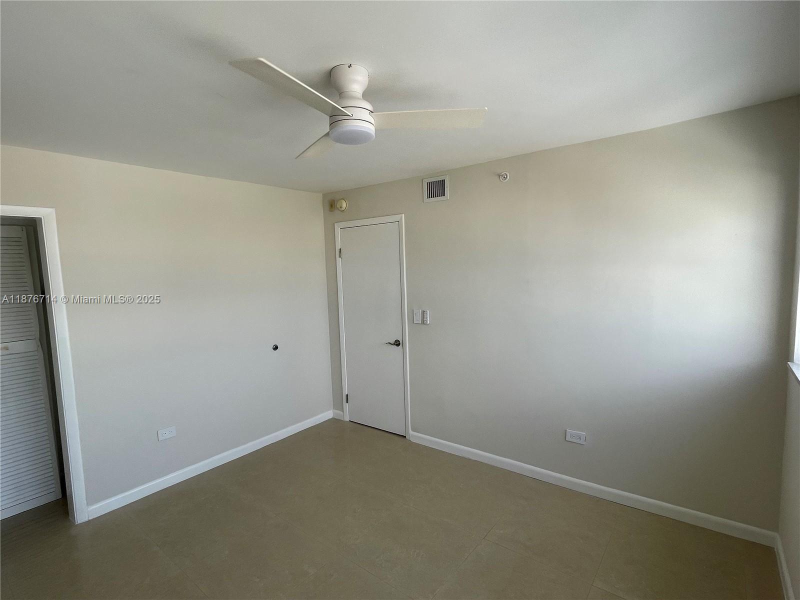 1881 Washington Avenue, Unit 15C Miami Beach, FL 33139 - Photo 14 of 30 an empty room with a ceiling fan and a window