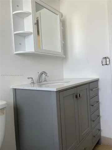 a close view of two sink a mirror and cabinets