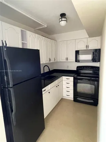 a kitchen with stainless steel appliances a refrigerator stove and white cabinets