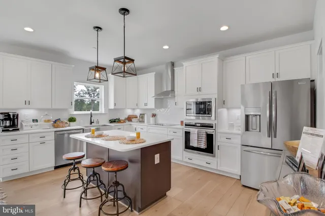 a kitchen with a center island appliances and cabinets