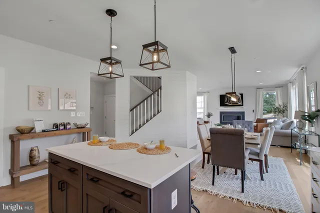 a view of a dining room and livingroom with furniture wooden floor a chandelier