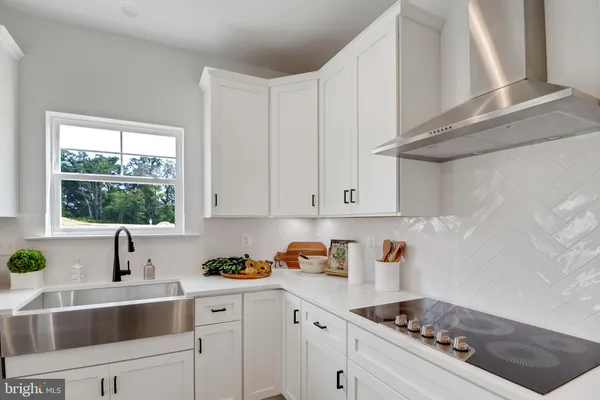 a kitchen with stainless steel appliances a white stove top oven cabinets and a window