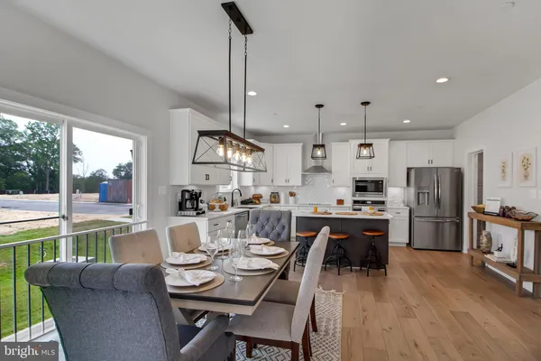 a living room with stainless steel appliances kitchen island granite countertop furniture and a wooden floor