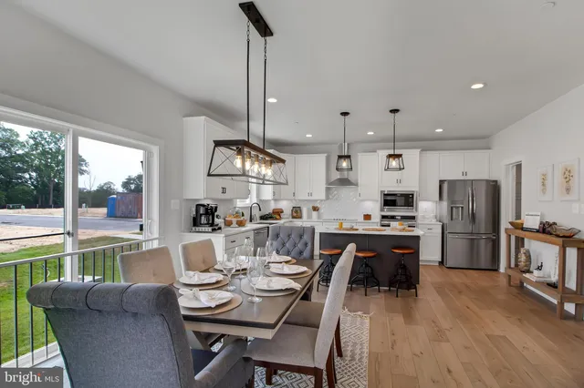 a living room with stainless steel appliances kitchen island granite countertop furniture and a wooden floor