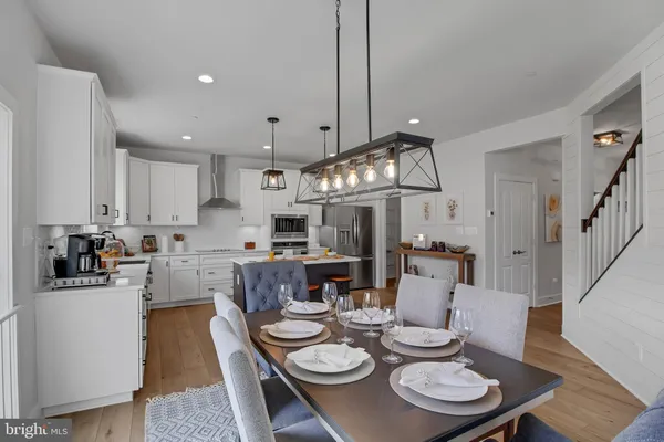 a open dining room with furniture wooden floor and kitchen view