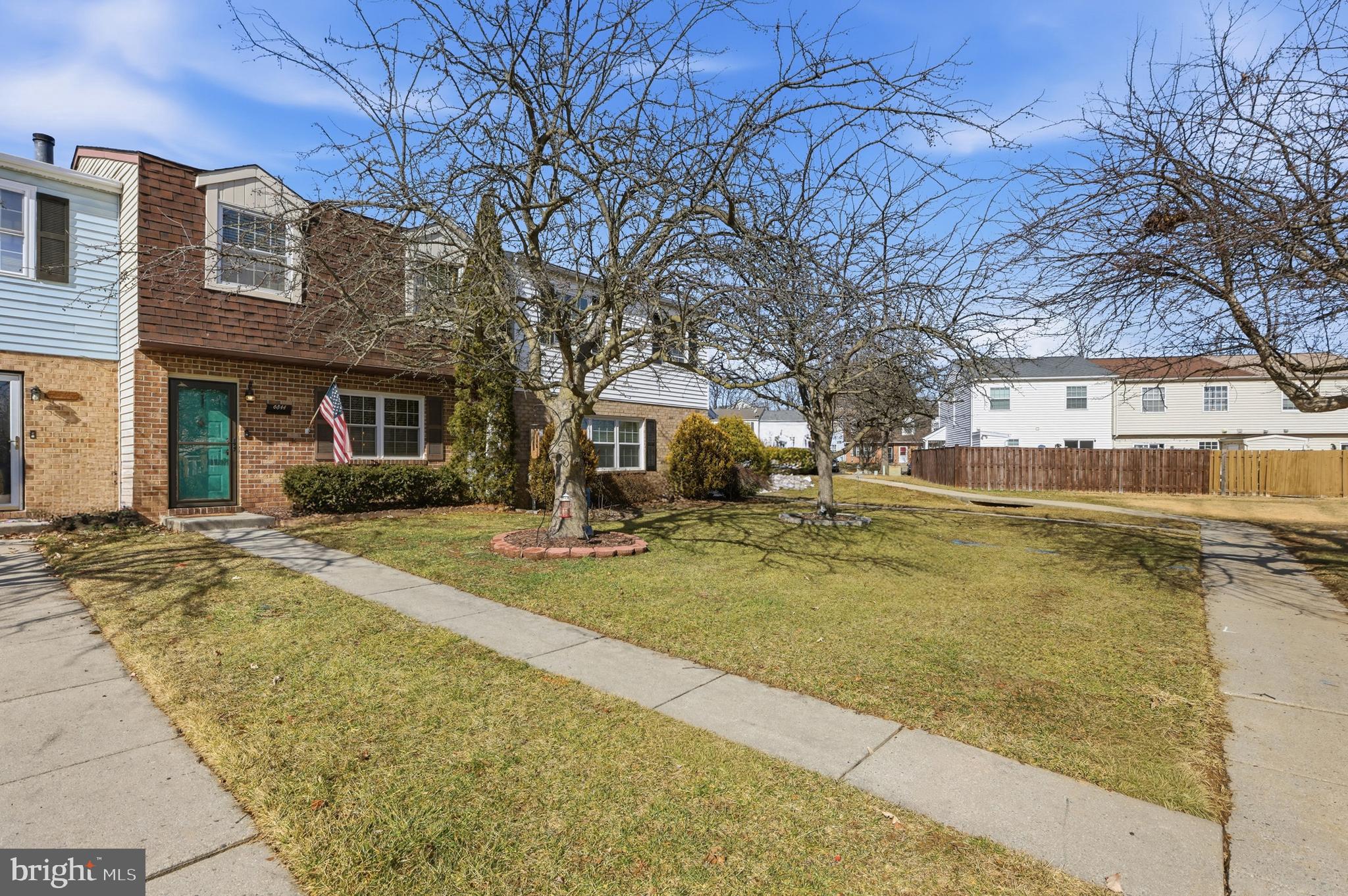 a view of a white house with a large tree